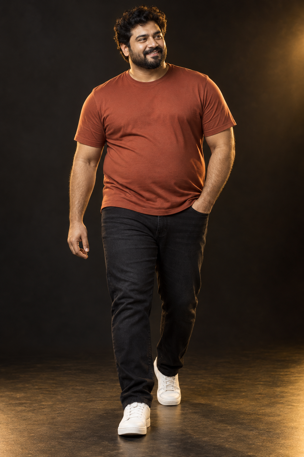 Plus-size male model wearing a rust T-shirt and black jeans
